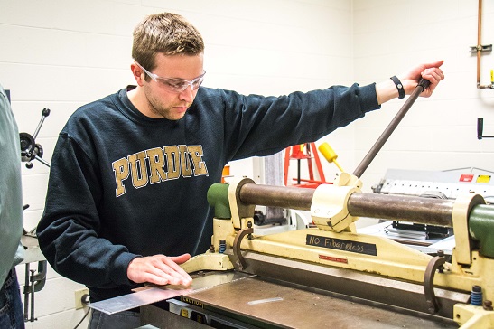 Student using sheet metal shear